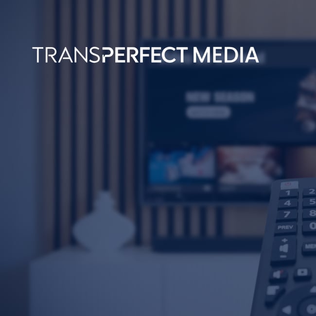 A hand holding a TV remote control, pointing it at a TV that has a streaming platform on it. 